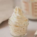 Piped whipped cream in a small mason jar.