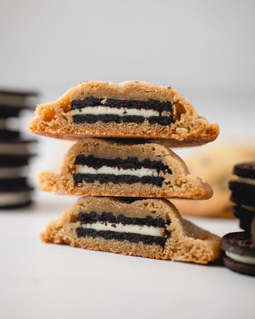 A stack of three Oreo stuffed peanut butter cookies cut in half to reveal the cookie inside.