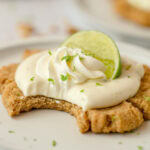 Graham cracker cookie topped with key lime pie filling with a bite removed.