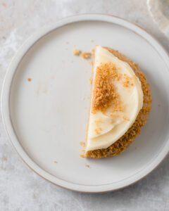 Half of a Crumbl New York Cheesecake Cookie on a small plate.