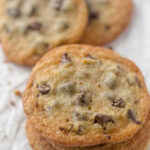A stack of chocolate chip cookies with golden brown edges.