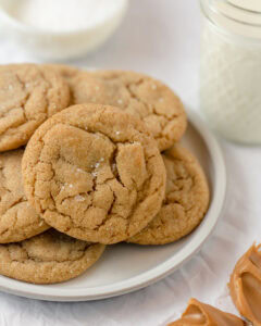 A plate of peanut butter cookies with flaked sea salt sprinkled on top.