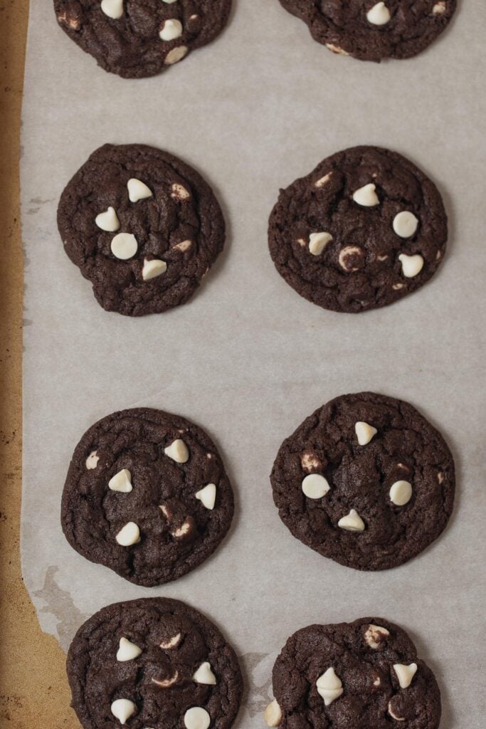 Baked double chocolate cookies on a lined baking sheet.