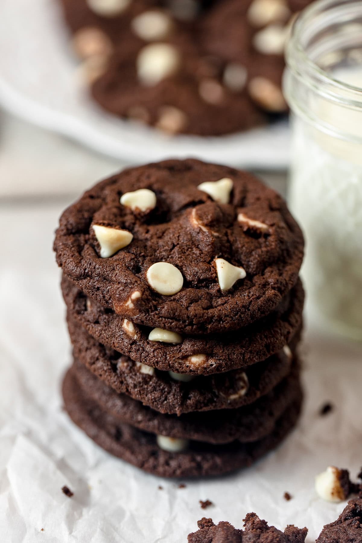 Double chocolate cookies in a stack on top of crinkled parchment paper.