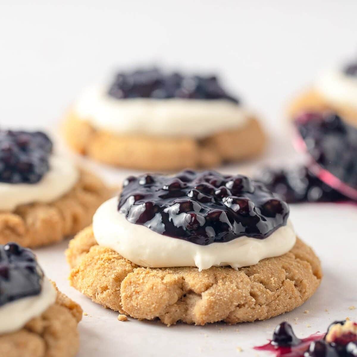 Graham cracker cookies piled high with a cheesecake frosting and blueberry pie filling.