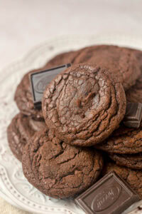 Brownie cookies on a plates with squares of chocolate alongside.
