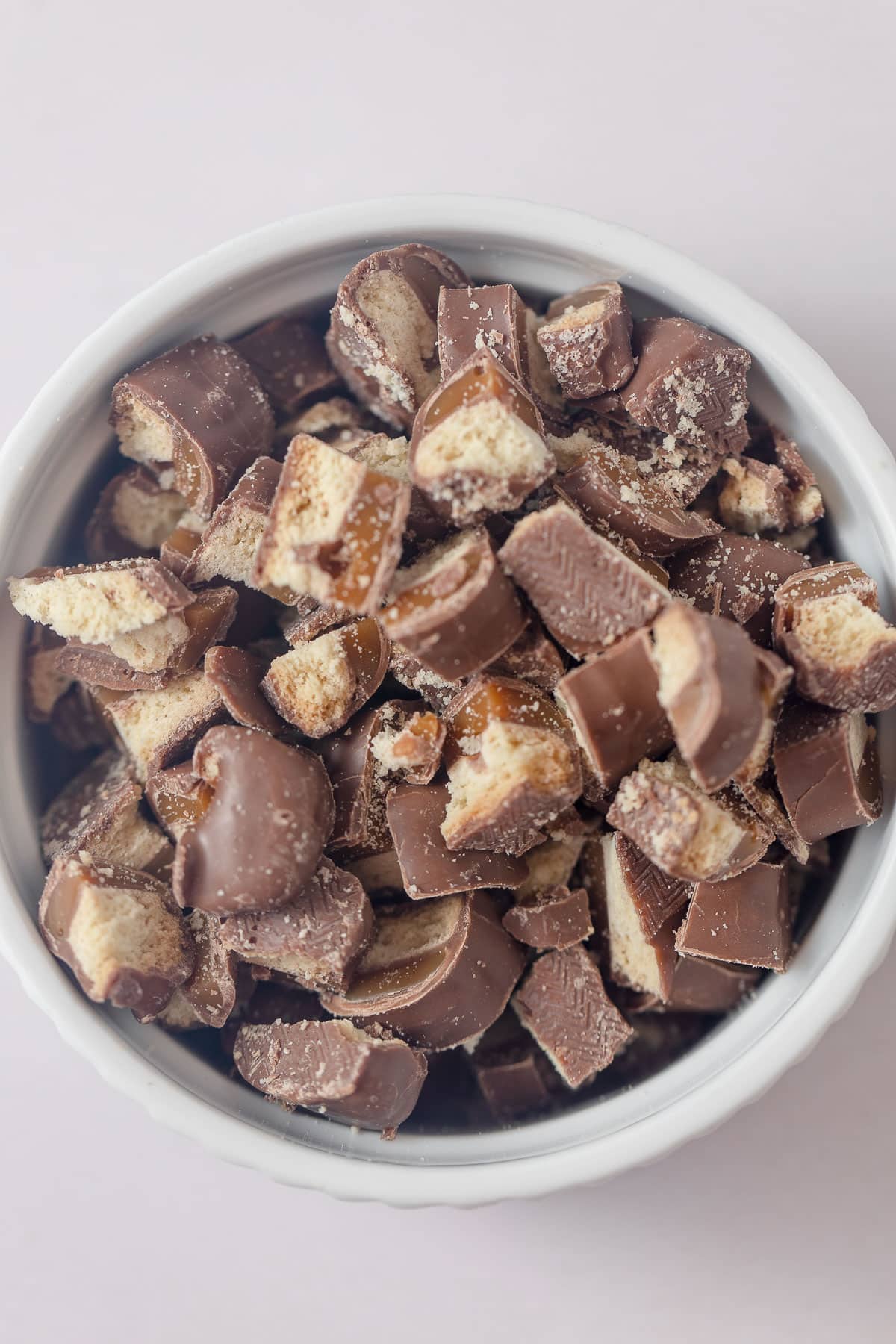 A bowl of chopped up Twix (caramel, chocolate, shortbread) bars.