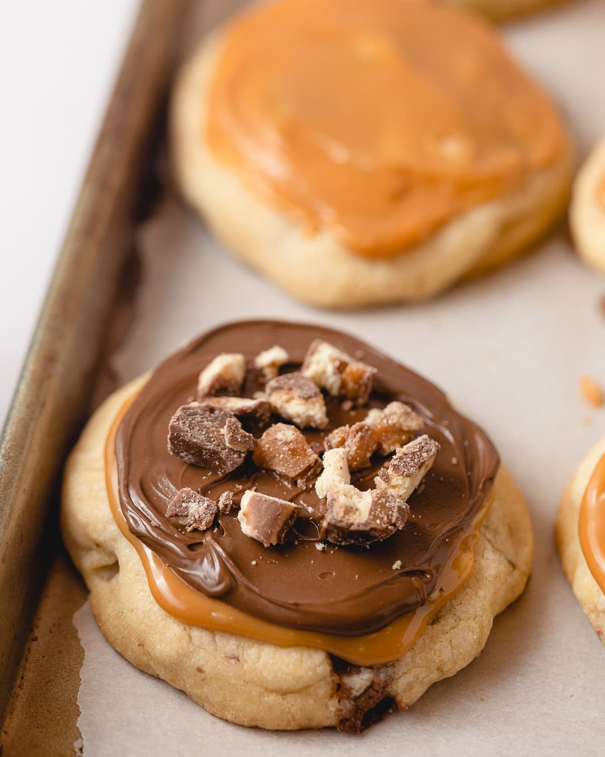 A cookie topped with swirled caramel and chocolate.