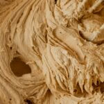 A swirly bowl of peanut butter buttercream frosting.