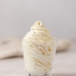 Piped soft yellow banana mousse in a glass.