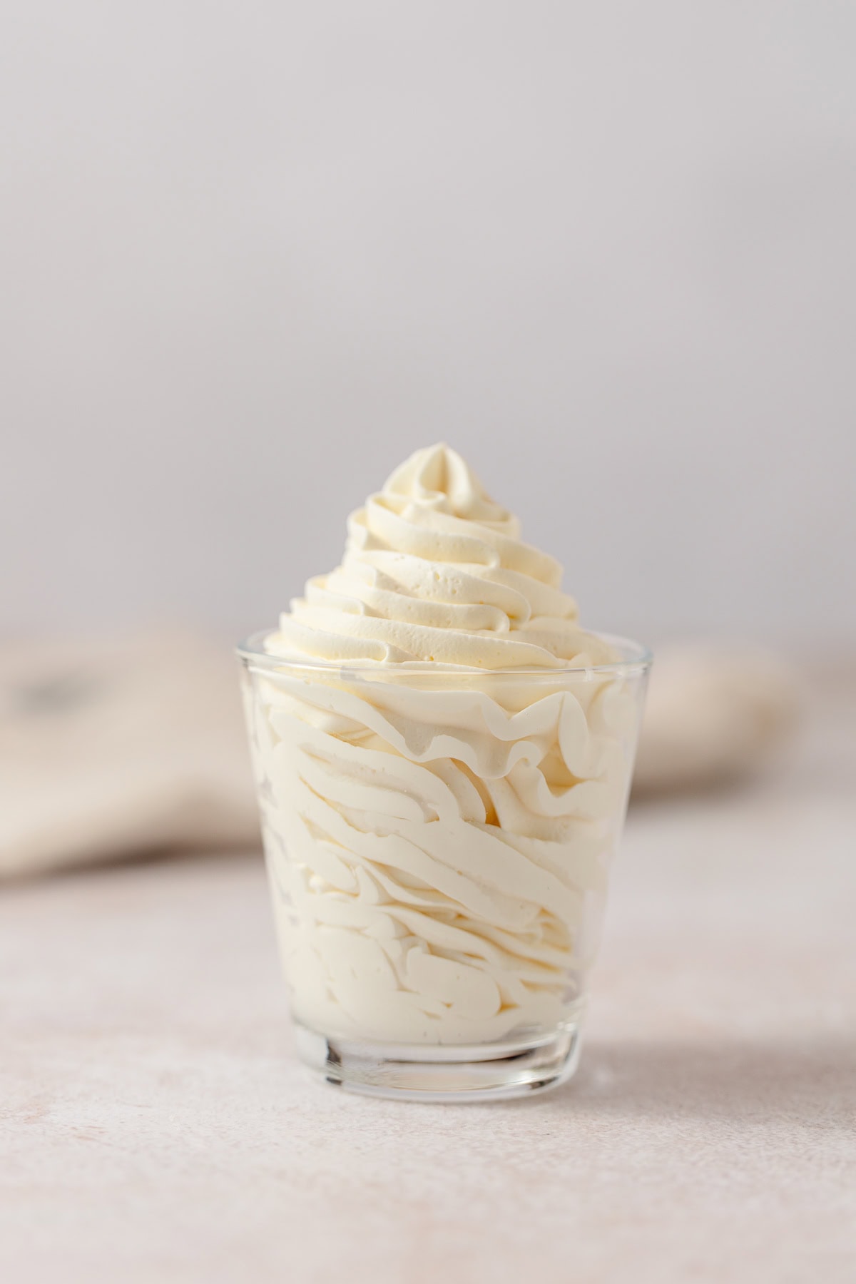 Piped soft yellow banana mousse in a glass.
