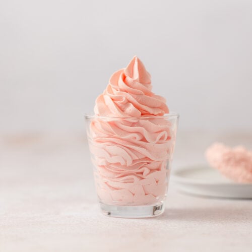 Piped pink strawberry mousse in a glass.