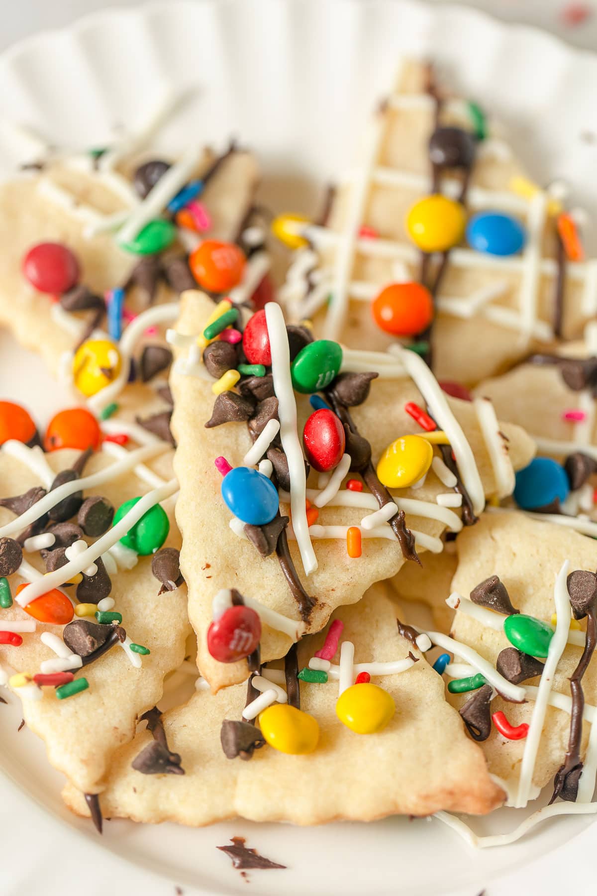 Sugar cookie "nachos" topped with drizzles of chocolate and mini chocolate candies in a variety of colors.