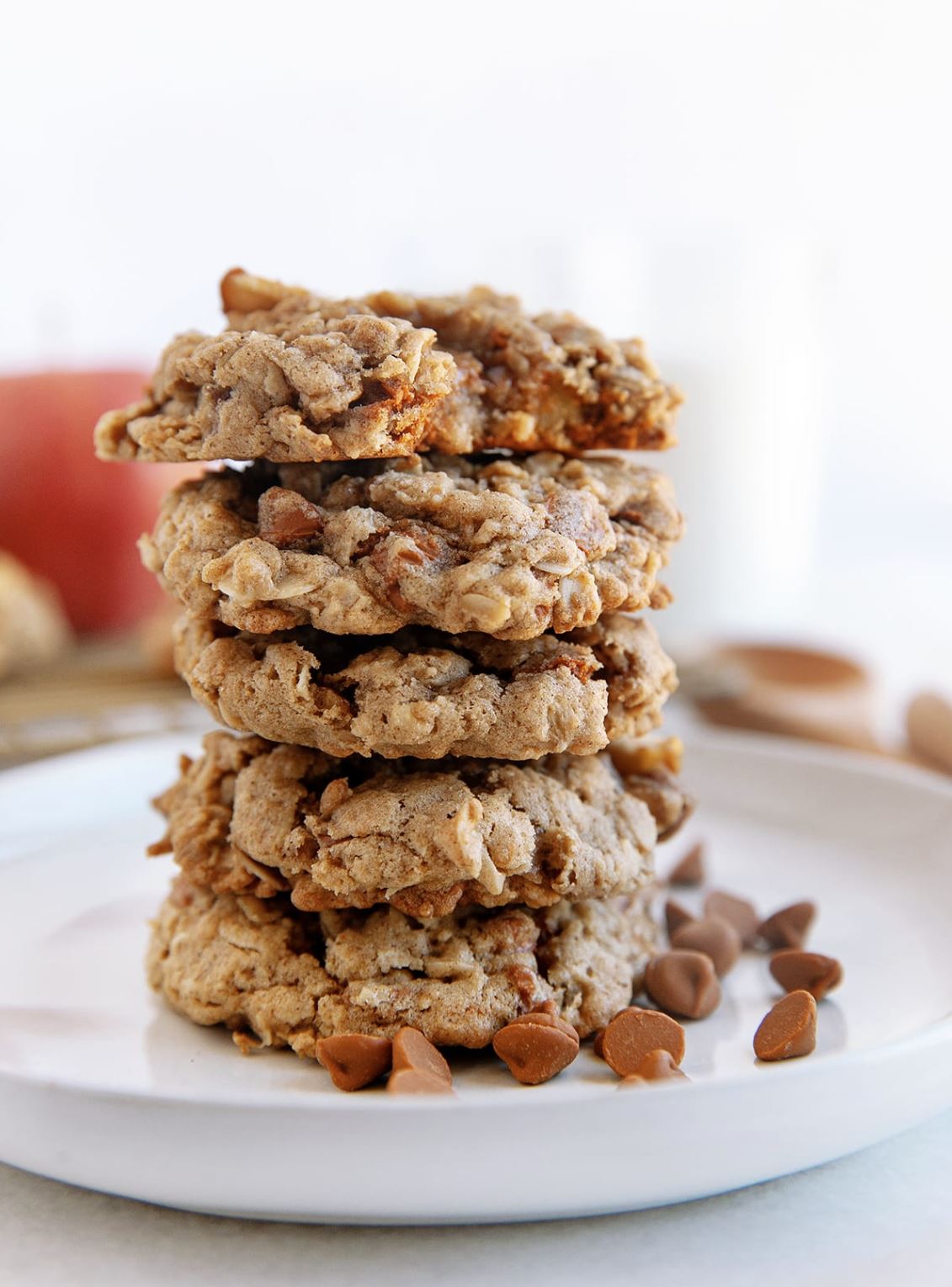 A stack of apple cookies with cinnamon chips on a white plate.
