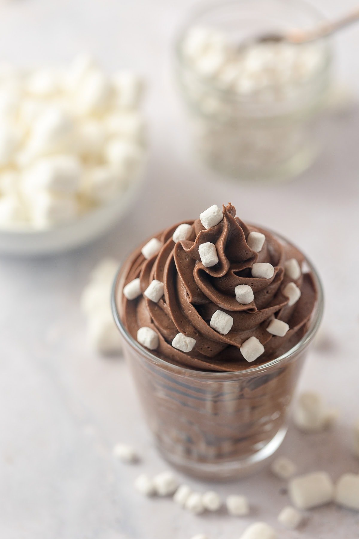 Piped chocolate buttercream in a glass jar topped with very tiny marshmallows.