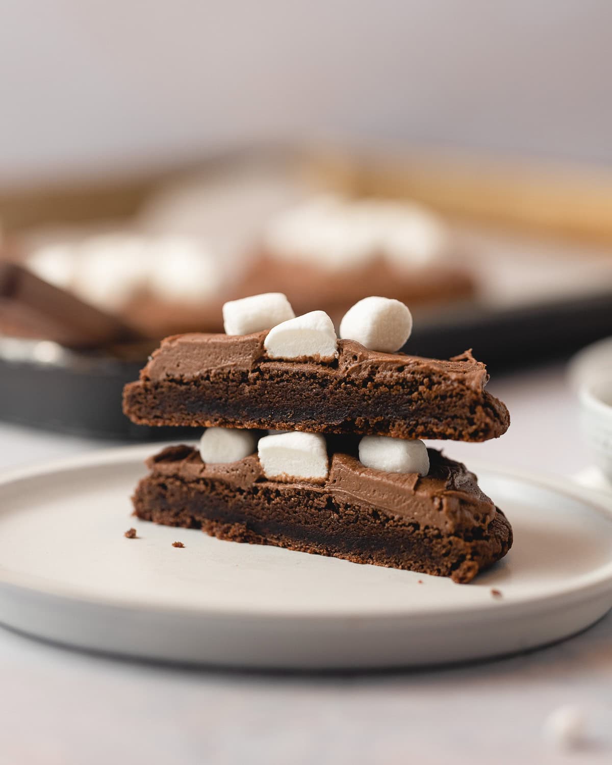 A frozen hot chocolate cookie cut in half and stacked on a plate.