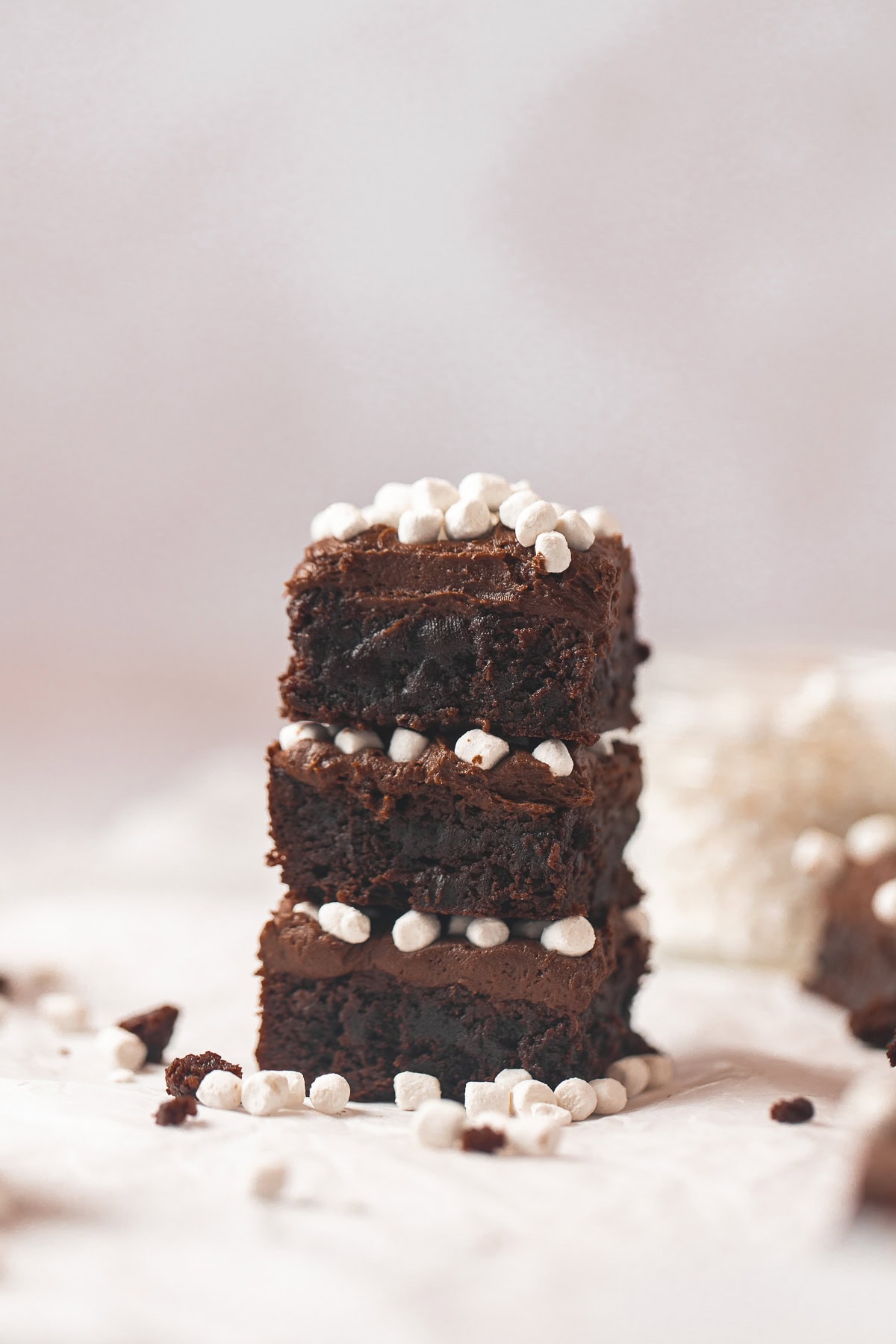 A stacked of brownies frosted with chocolate frosting and topped with mini marshmallows.