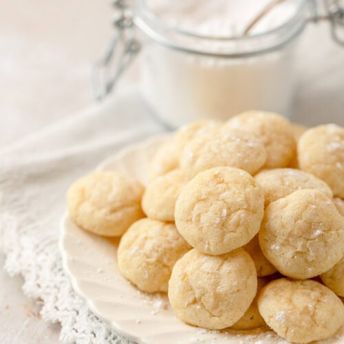 A plate filled with light yellow mini lemon cookies.