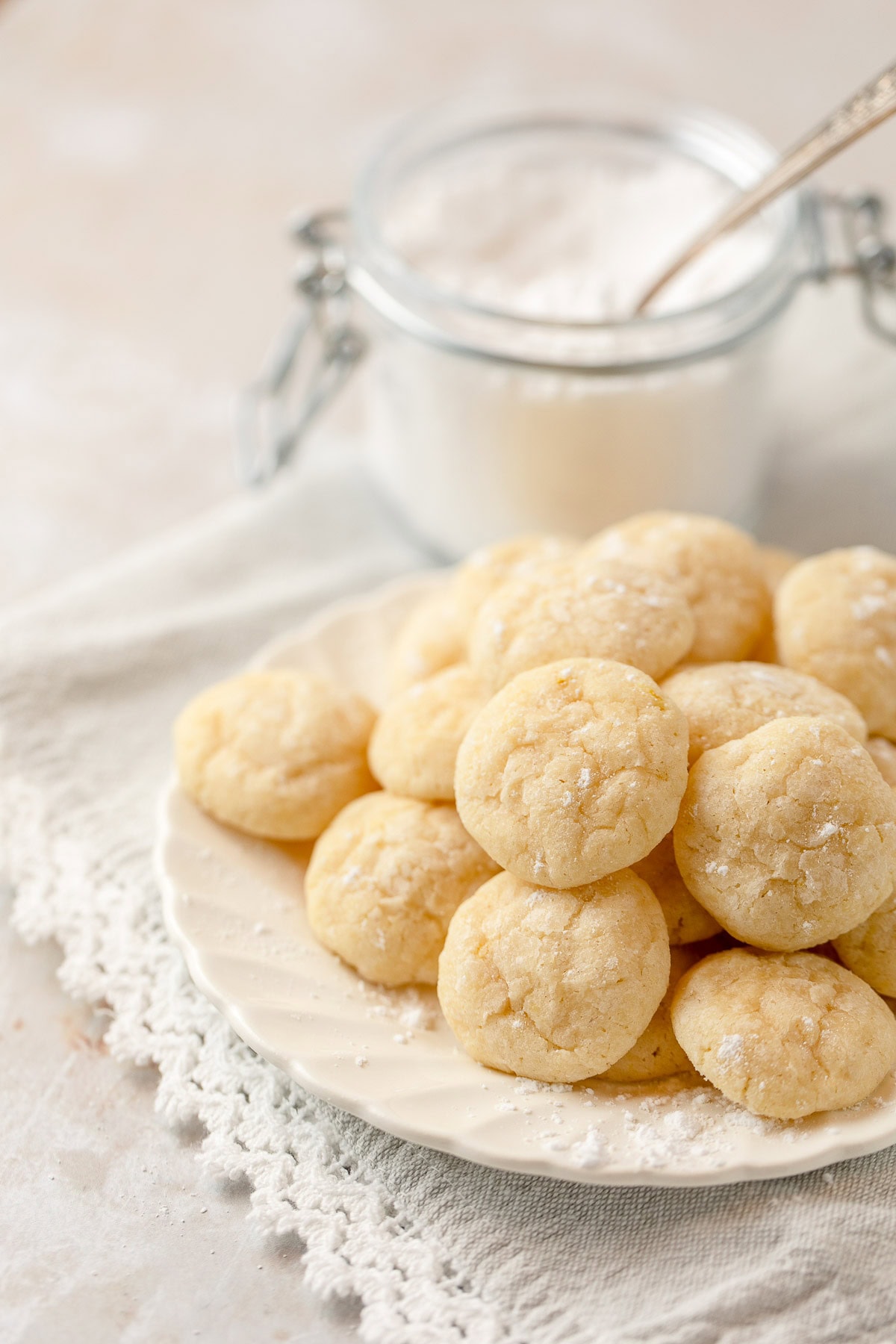 A plate filled with light yellow mini lemon cookies.