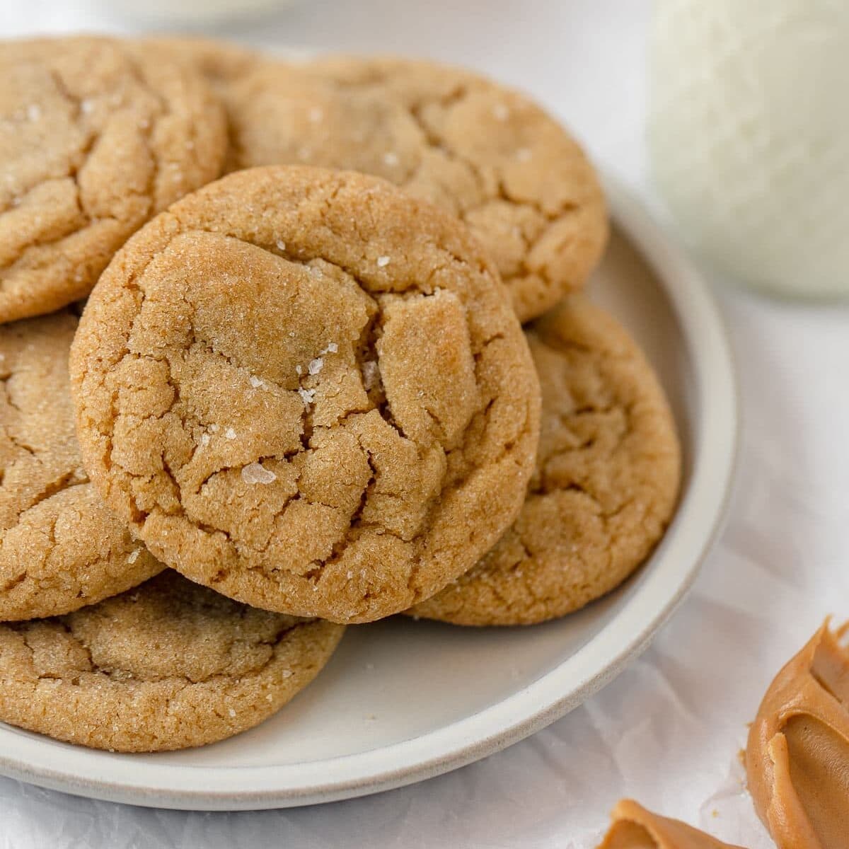 A plate of peanut butter cookies with flaked sea salt sprinkled on top.