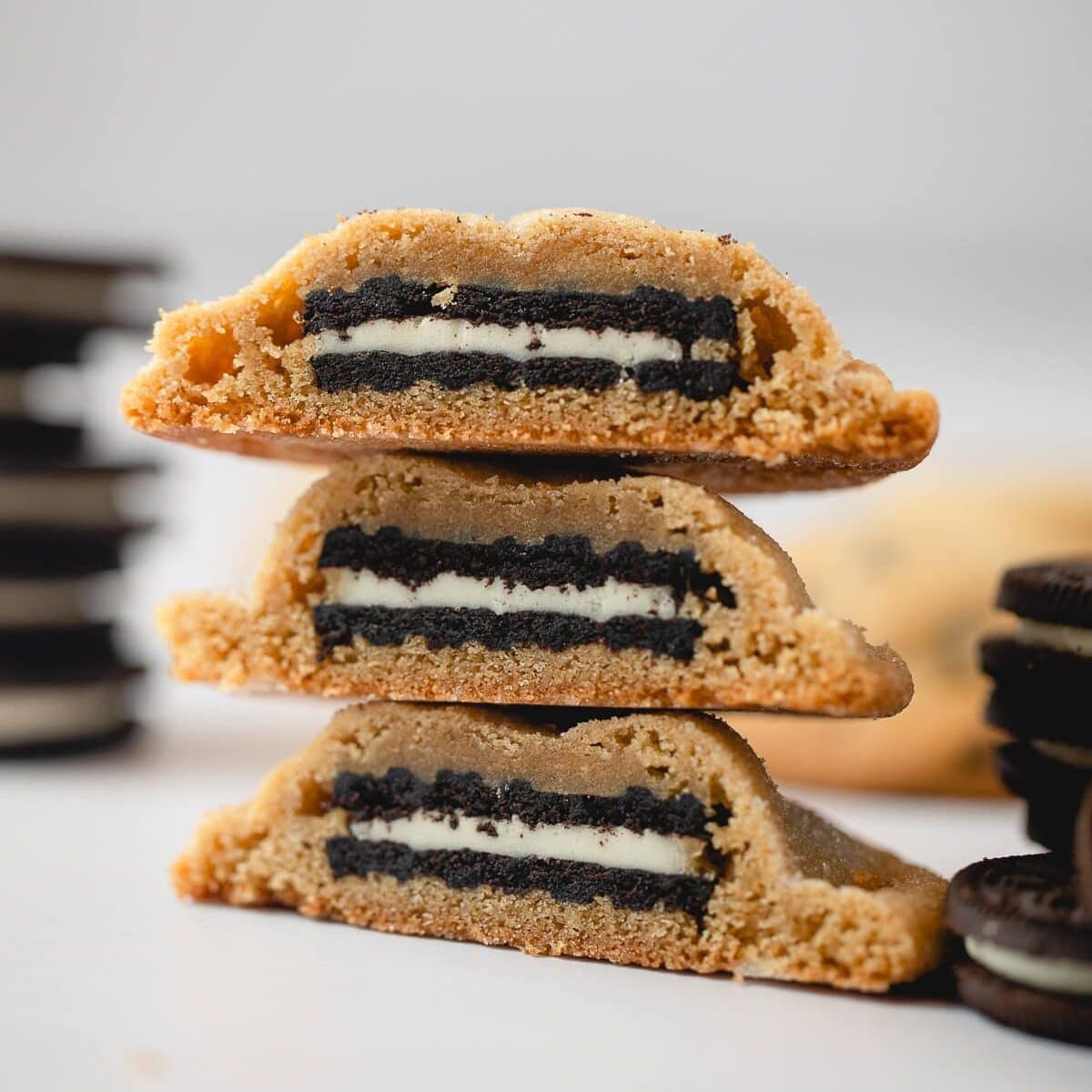 A stack of three Oreo stuffed peanut butter cookies cut in half to reveal the cookie inside.